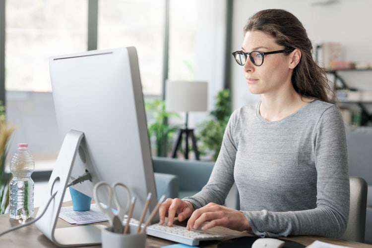 A woman uses a computer to automate her accounts payable workflow.