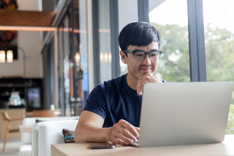 A man uses his laptop to create a limited partnership agreement.