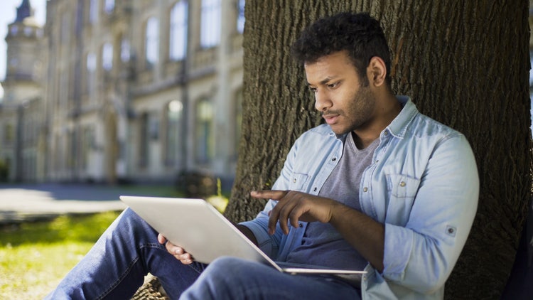 A man reviews and electronically signs a job offer letter using his laptop.