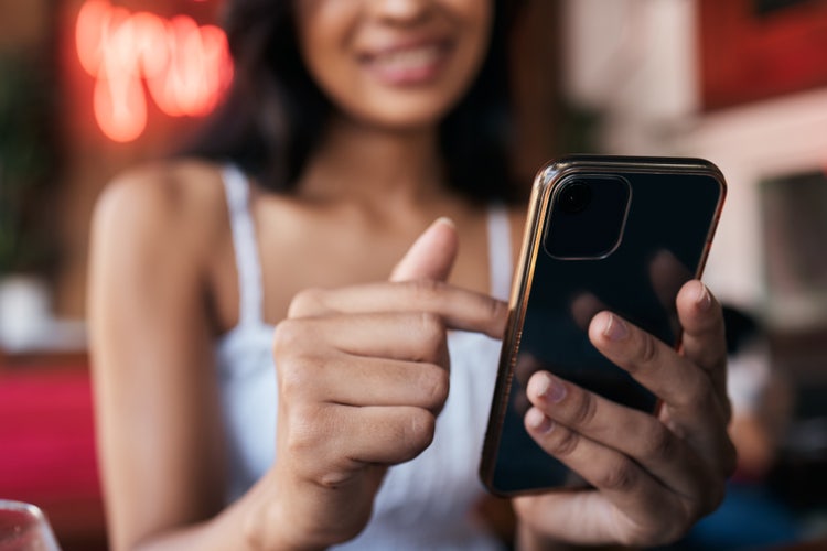 A woman uses her iPhone to electronically sign a Word document.