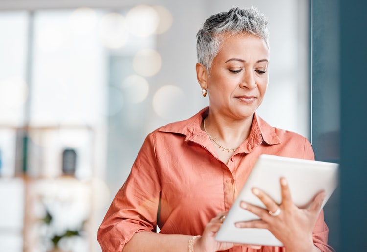 A woman looks at an HR job application form on her tablet.