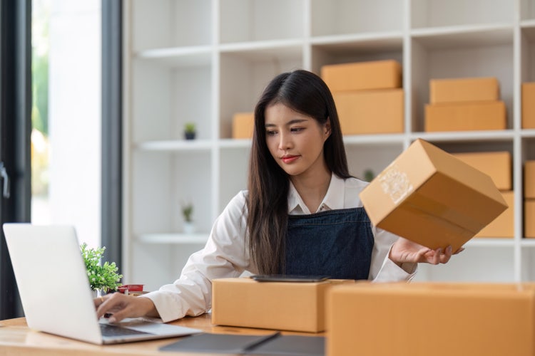 A woman reviews a purchase order to verify items received in a shipment.