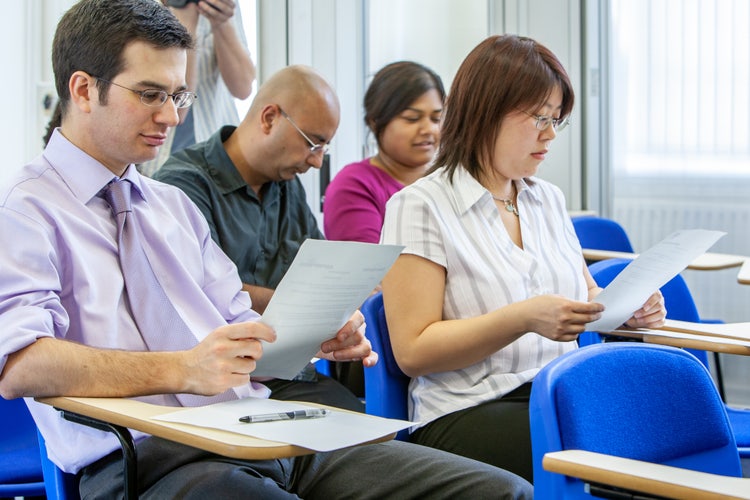 A group of new hires review an NDA before signing it.