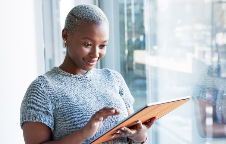 A woman reviews employee onboarding documentation for with esignatures on a tablet.