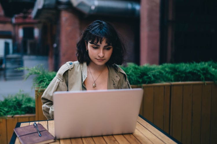 A business professional uses her laptop computer to create a small business invoice.