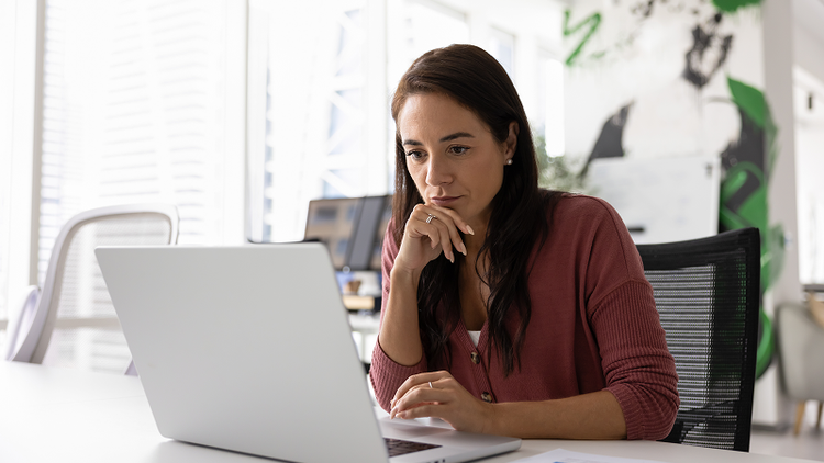 A woman at a laptop uses Adobe Acrobat for business to organize her sales contracts.