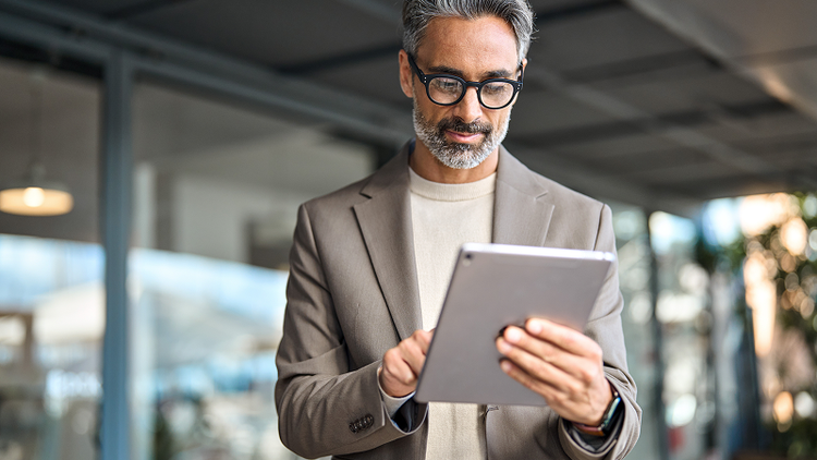 A man signs a sales agreement on his tablet.