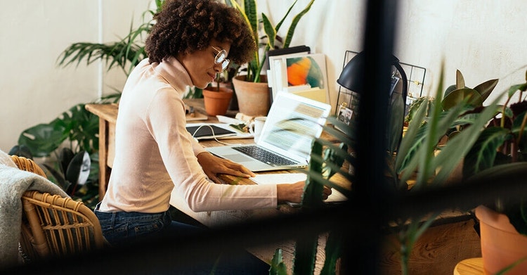 A person writing grant proposals at their desk