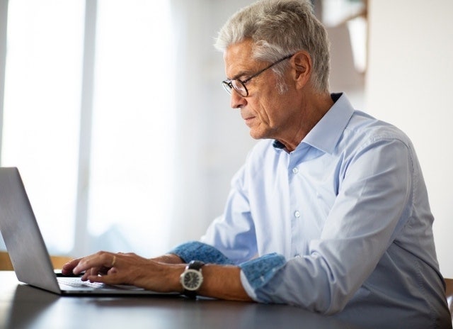 A photo of a person working on an advance directive on a laptop computer.