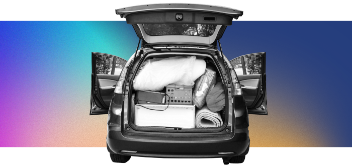 The trunk of a van is packed with various items.