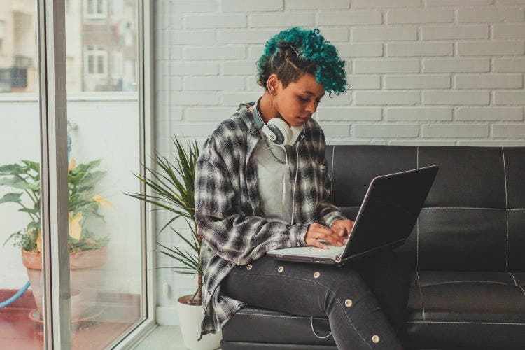 A young person sits on a couch with a laptop editing a PDF in Windows 10.