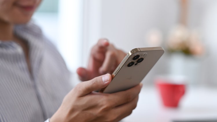 A woman holding a phone exports text messages from her iPhone to be PDF files.