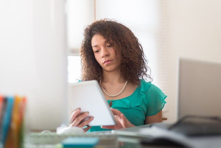 A young woman uses an iPad to share a PDF.