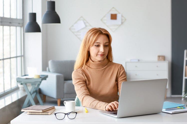 A person using a laptop to convert DWF to PDF.