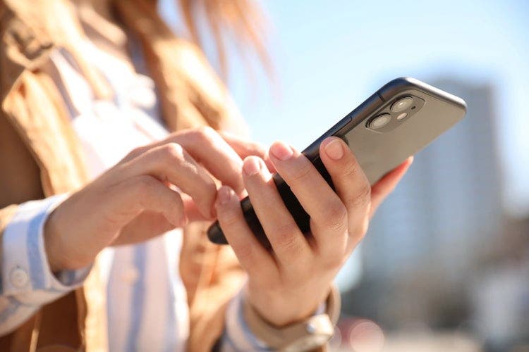 A woman on an iPhone redacts a PDF.