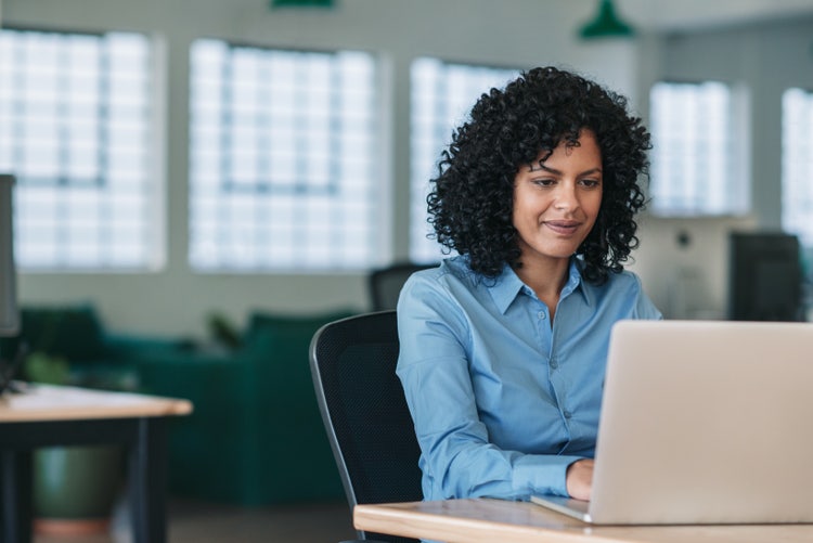 man uses the Find and Replace feature in a Word document on her laptop.