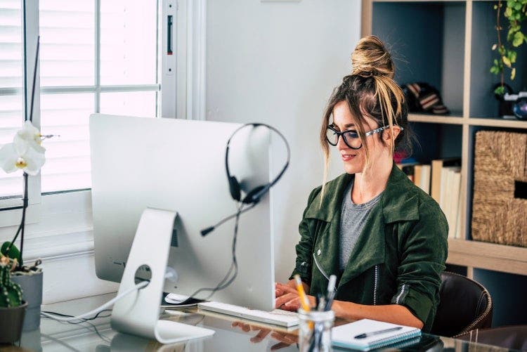 A woman in an office merges PDF files using her Mac.