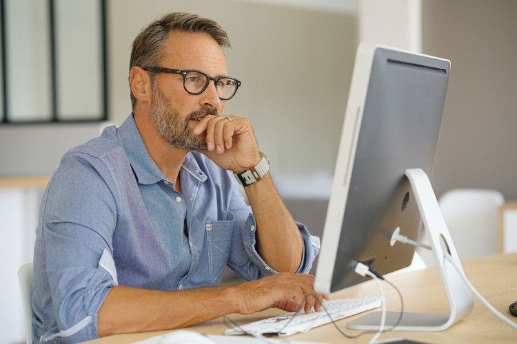 A man converts a PowerPoint to Google Slides on a desktop computer.