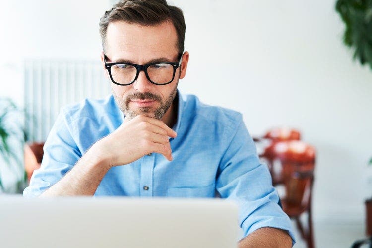 A man uses his laptop to convert his Gmail emails to PDF documents.