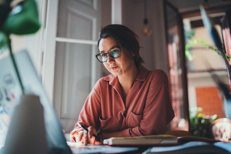 A woman uses a Chromebook to combine PDFs.