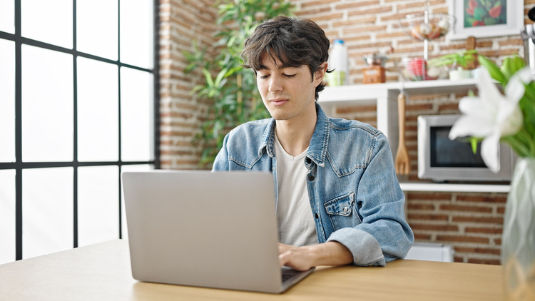 A student uses his laptop to learn how to write an abstract for a paper.