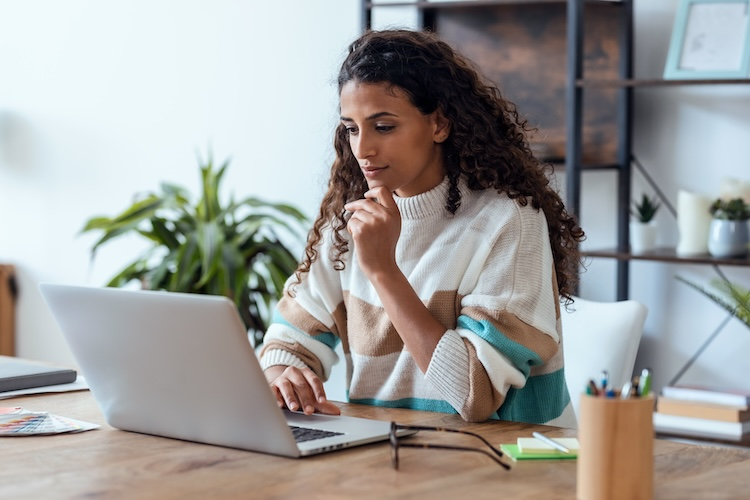 A woman uses her laptop to combine Word documents.