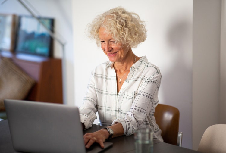A woman uses her laptop to notarize her documents electronically.