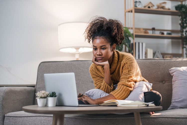 A woman uses her laptop to format a book report.