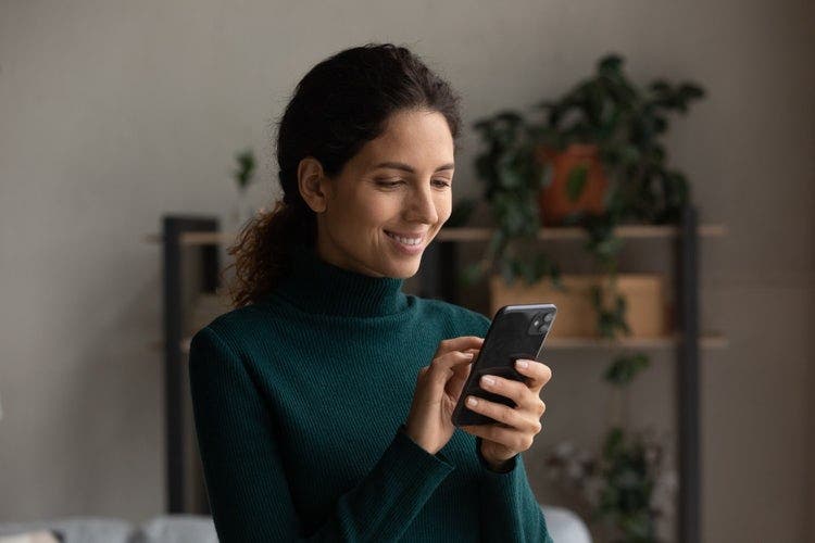 A woman uses a mobile phone to convert a PDF to JPG