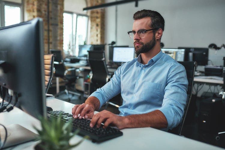 A man rotates a PDF on a PC at an office.