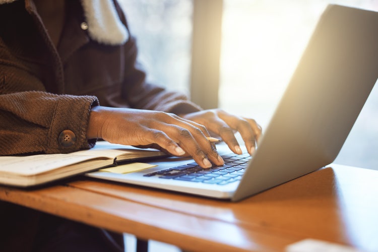 A person typing on a laptop, creating an effective study guide.