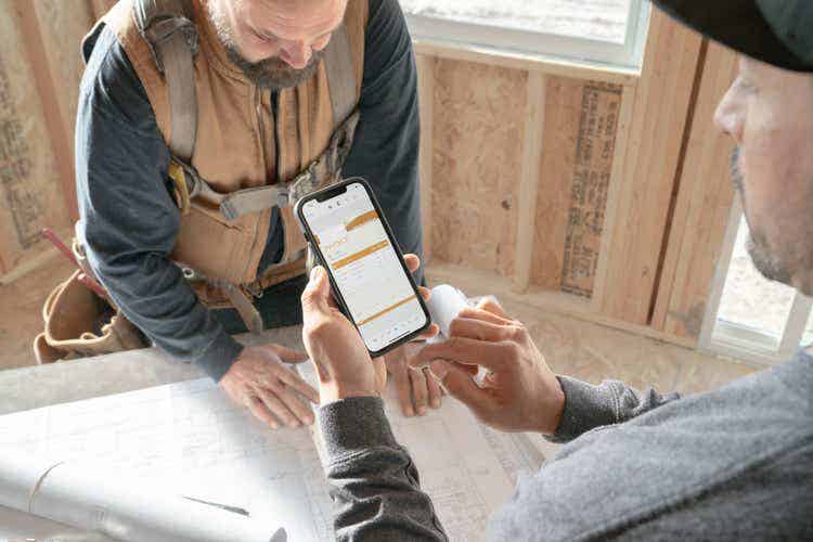 Two builders working on plans create a fillable PDF on an iPhone.