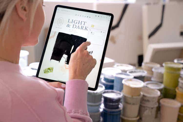 An artist in a workshop uses a Mac device to annotate a PDF.