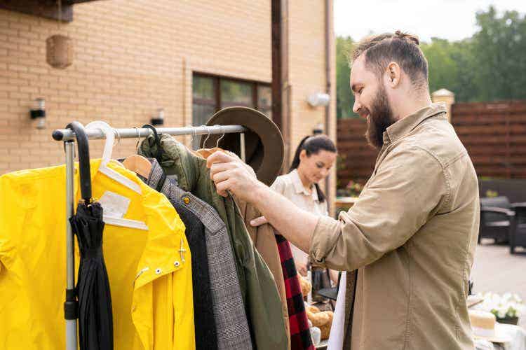 A man browses for clothes at a yard sale.