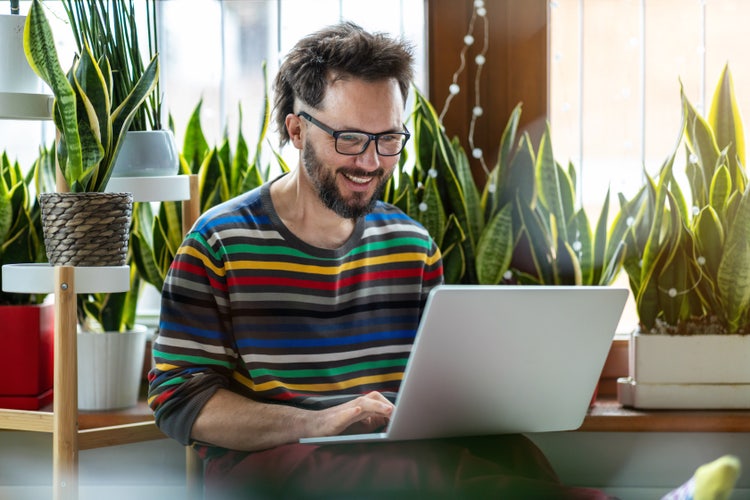 A man in an office uses his laptop to create an email sign-up list.