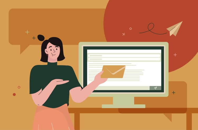 A woman holds a paper envelope in front of a desktop.