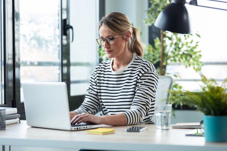 A woman uses her laptop to learn how to create a portfolio., Picture