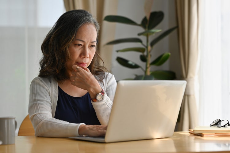 A woman uses her laptop to learn how to sign as power of attorney (POA).