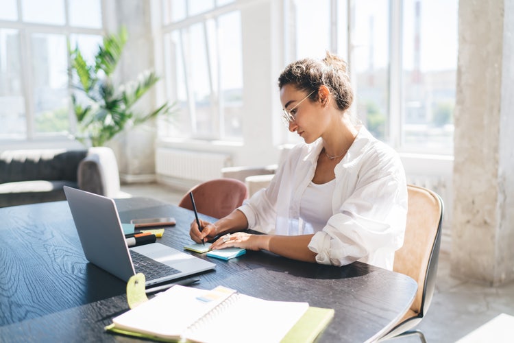 A woman works on improving operational efficiency for her one-person business.
