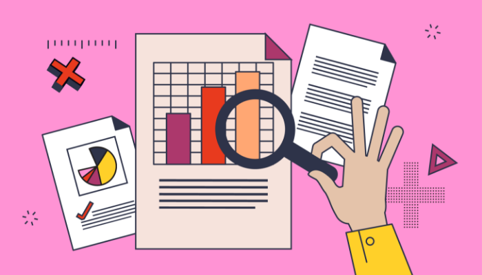 A hand holds a magnifying glass over a bar graph in a business report, signifying how reports should be finalized for accuracy.