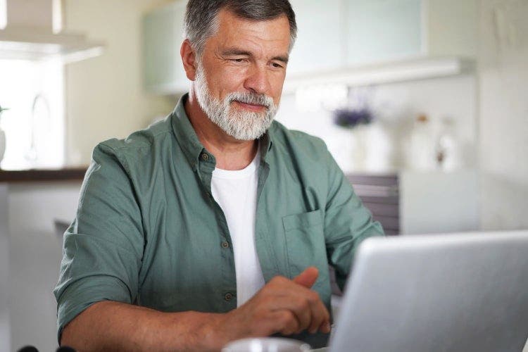 A man typing on a PDF on a Chromebook.