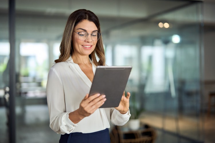 A woman holding a tablet merges comments from two PDF files.
