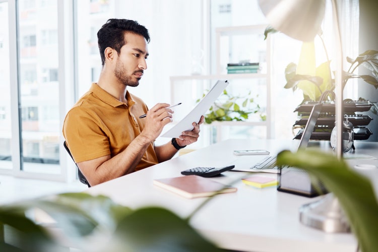 A man organizing tax documents at his desk.