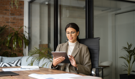 A woman in an office uses her tablet to resize a PDF.