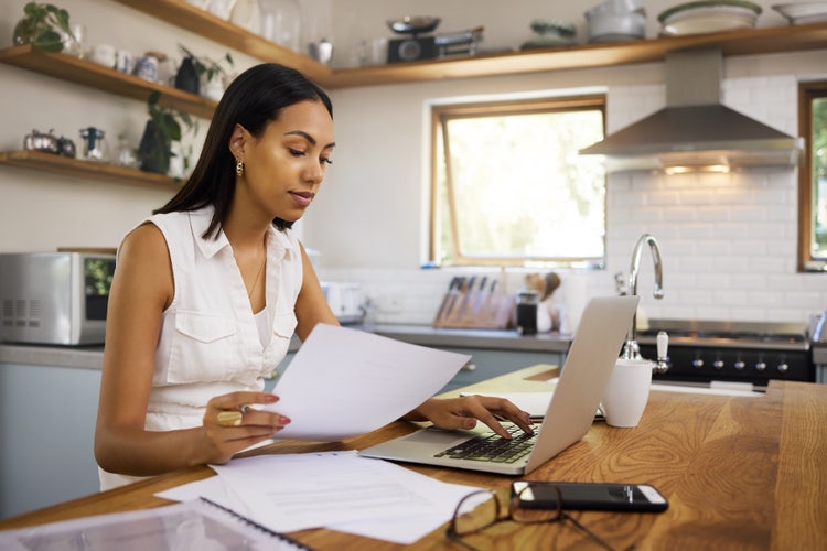 A woman digitizes bank statements to PDF using her laptop.
