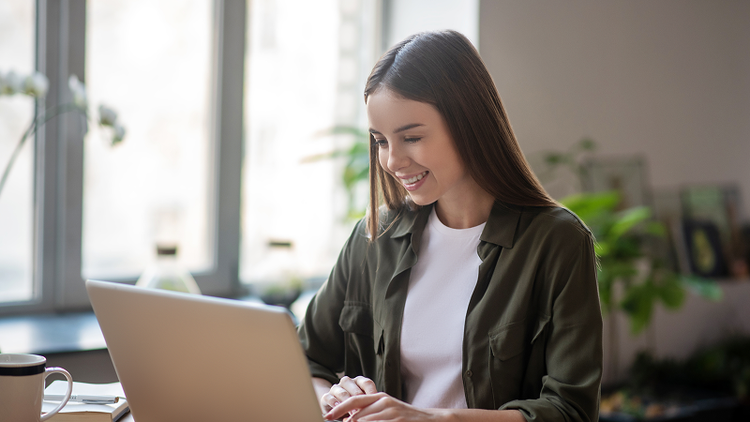 Woman smiling while using a computer to search a PDF.