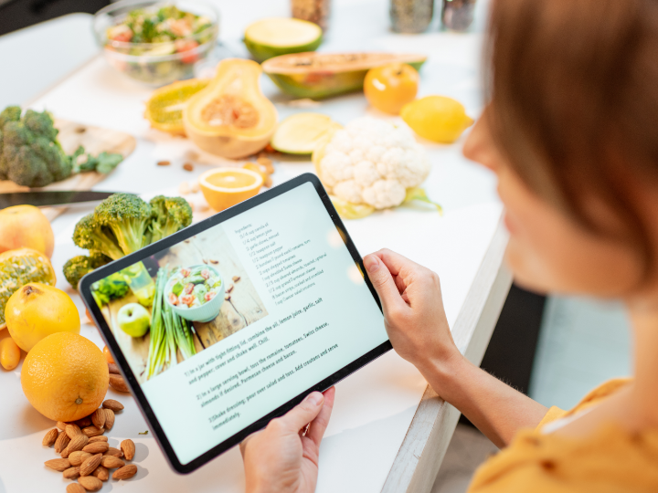 A tablet displays a PDF recipe book for a person preparing fresh ingredients.