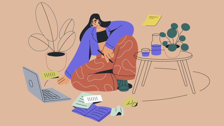 A woman with notebooks around her looks at her laptop.