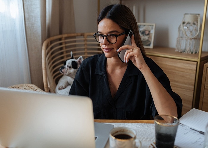 Person looking at their computer making PDF edits while talking on the phone