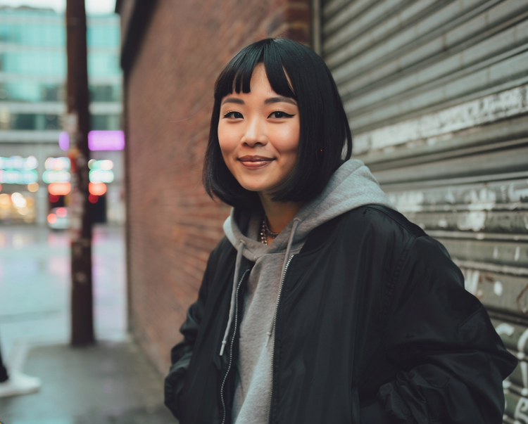 An AI-generated image of a cool-looking young women with a bright smile standing on a city street against a brick wall and sheet-metal garage door.